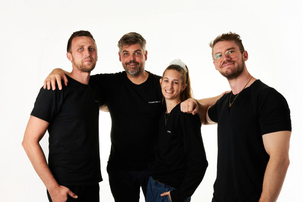 Fire fysioterapeuter fra Fysio360 i København smilende på klinikken i Gothersgade